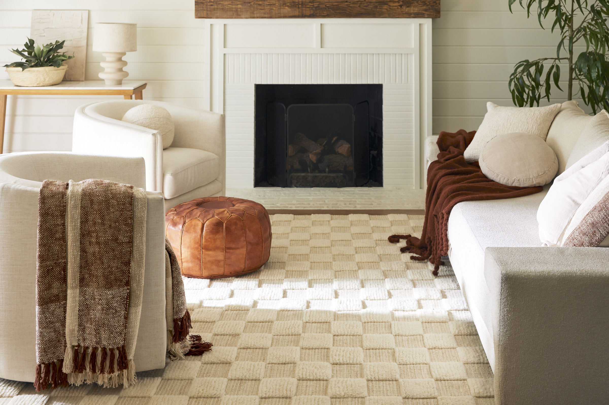 Living room with checkerboard rug and ivory furniture